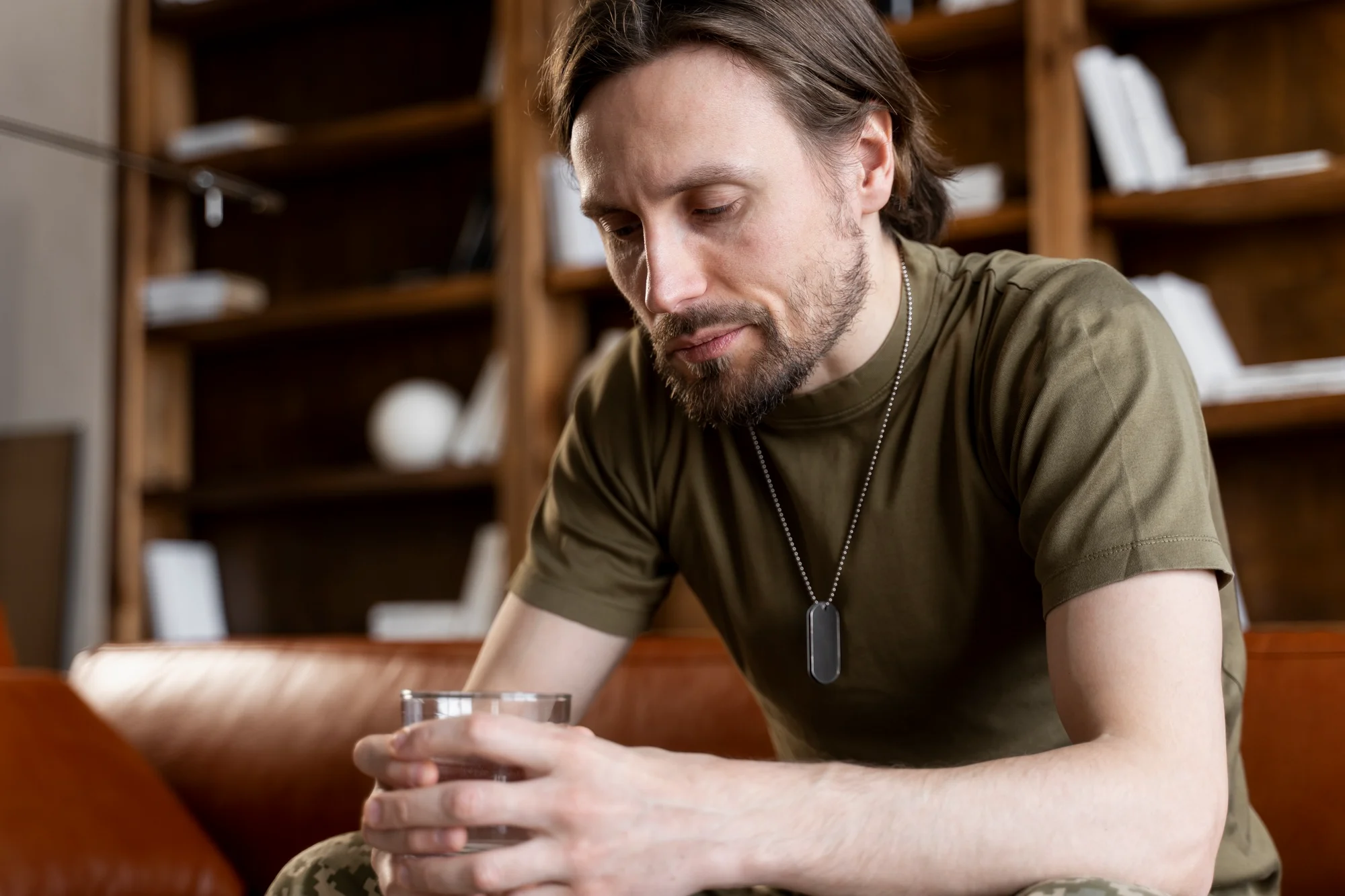 Man sitting alone looking down, struggling with substance use