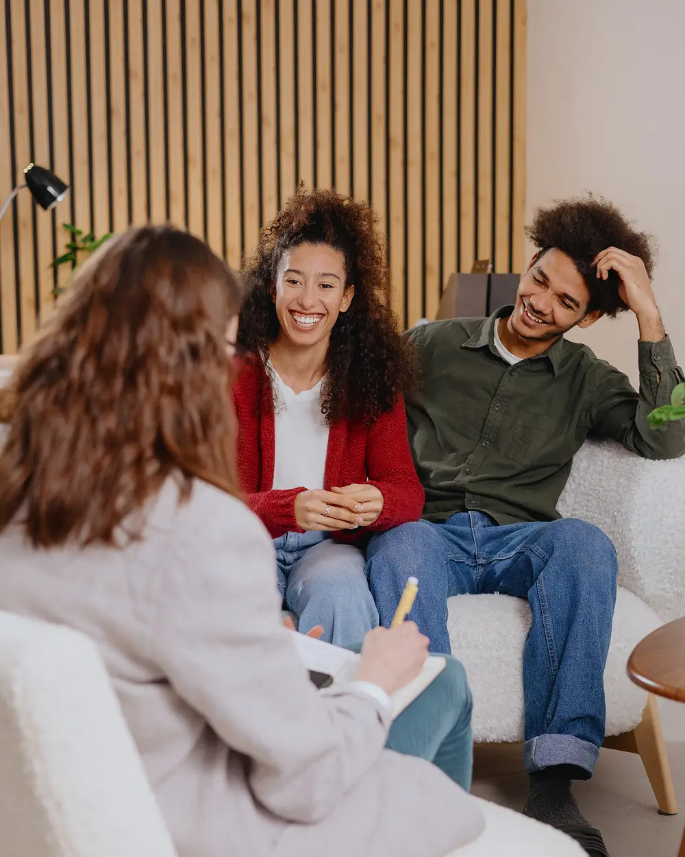 Friends supporting each other while sitting on a couch