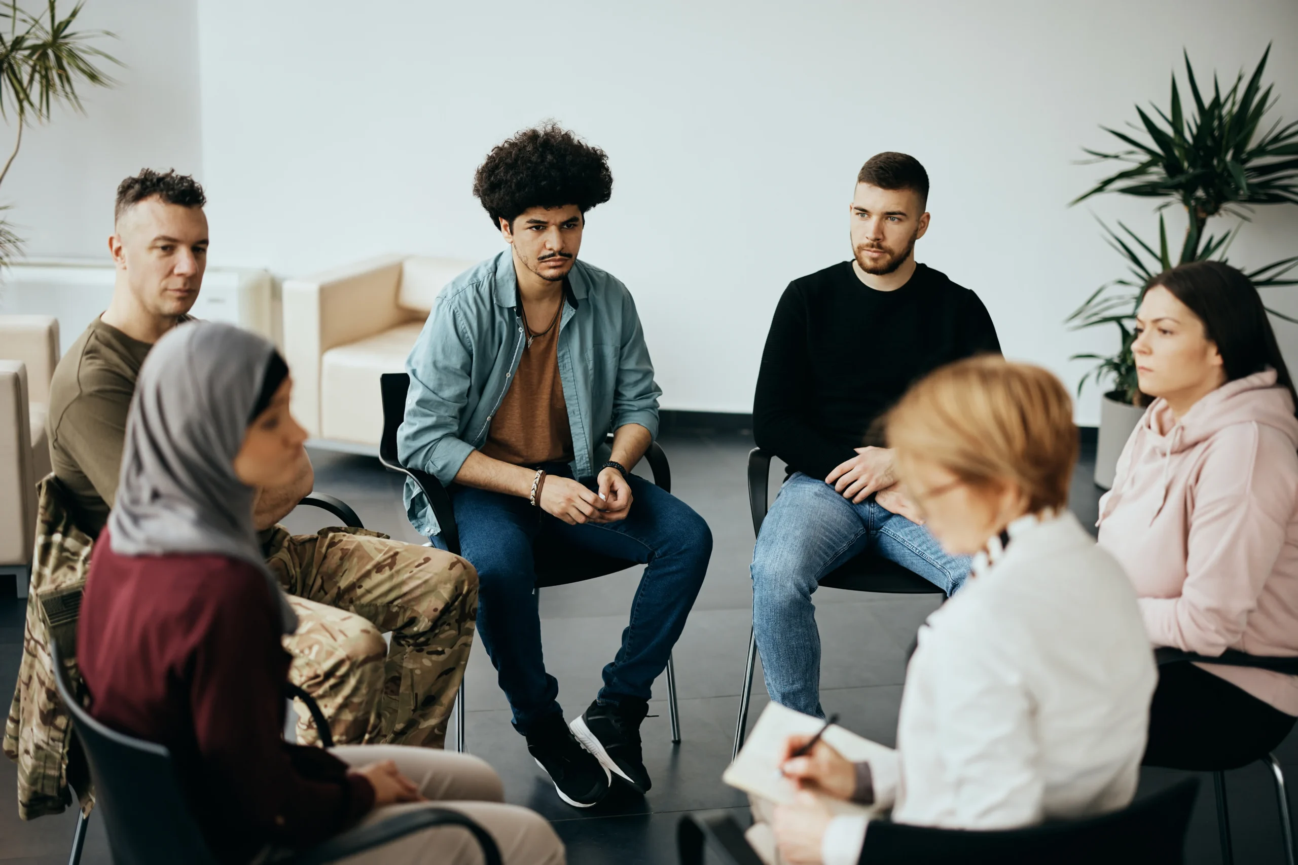 Support group sitting in a circle during a group therapy meeting