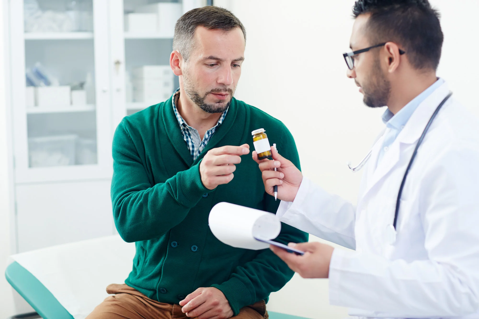 Doctor reviewing a prescription bottle with a patient